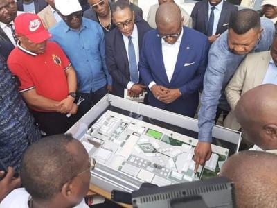Guillaume Manjolo et ses quelques collègues regardant la maquette du site des jeux de la francophonie 