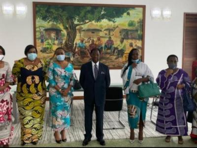 Thambwe Mwamba postant avec quelques femmes