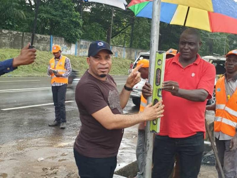 Jean Remi Yanga, président de la commission nationale de prévention routière plaçant un panneau avec un membre de la cnpr