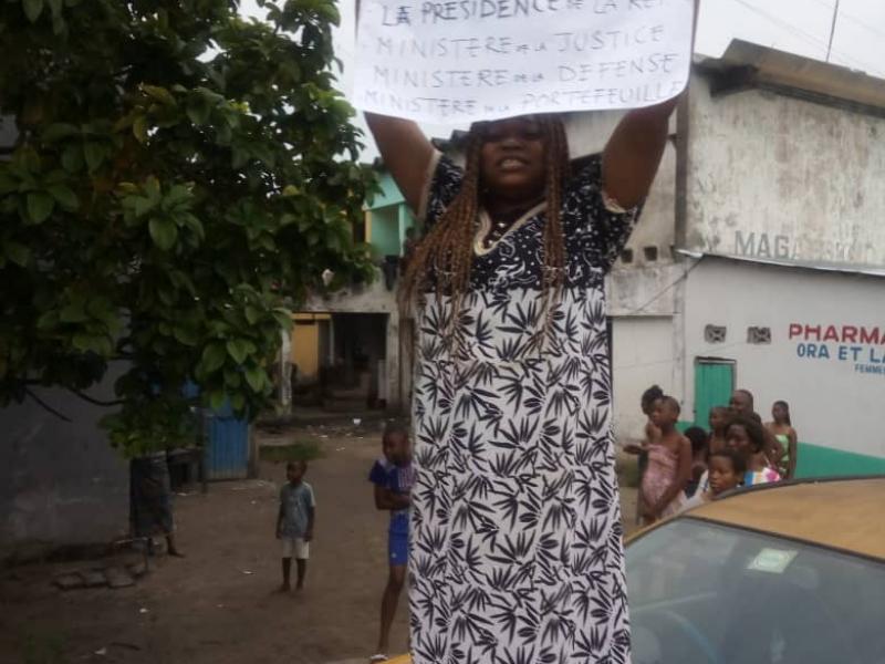 Une dame avec une affiche pour demander une audience 