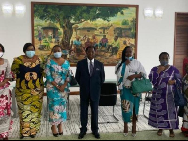 Thambwe Mwamba postant avec quelques femmes