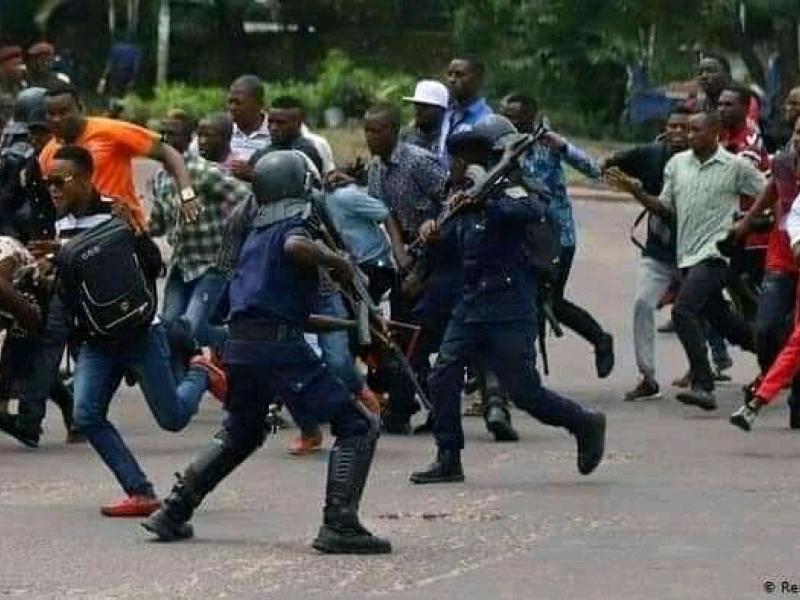 Quelques éléments de la police empêchant les manifestants de passer une barrière